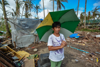 Women standing in front of her destroyed home after a storm